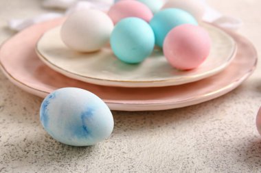 Plate of painted Easter eggs on light background, closeup