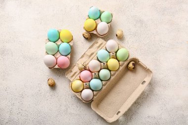 Holders with different Easter eggs on light background