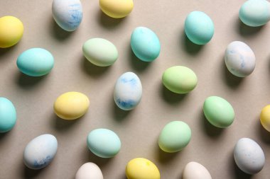 Many painted Easter eggs on grey background