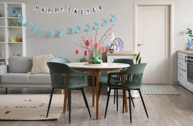 Interior of kitchen with tree branches, Easter eggs and dining table