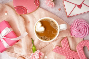 Composition with sweet cookies, cup of coffee and carnation flowers on table. Valentine's Day celebration