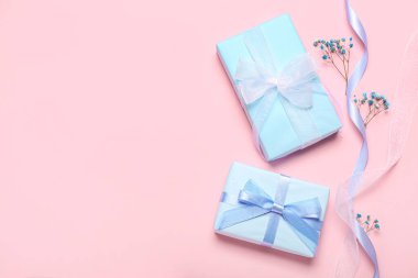 Composition with gift boxes, ribbon and gypsophila flowers on pink background. Women's Day celebration