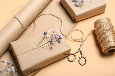 Gift boxes, wrapping paper, scissors and rope on color background, closeup. Women's Day celebration