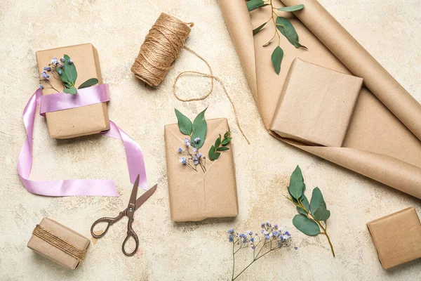 Composition with gift boxes, wrapping paper, rope and gypsophila flowers on light background. Women's Day celebration