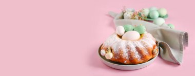 Tasty Easter cake and painted eggs on pink background with space for text