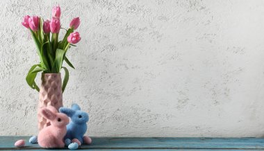 Beautiful tulip flowers, painted eggs and Easter bunnies on light background with space for text