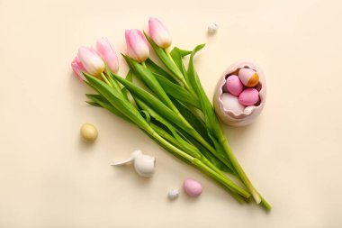 Composition with beautiful tulip flowers, Easter eggs and ceramic bunny on color background