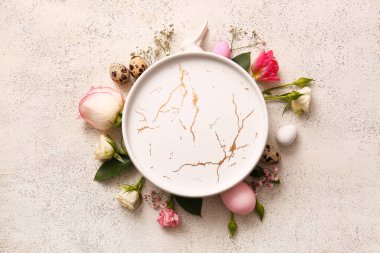 Composition with empty plate, beautiful flowers and Easter eggs on light background
