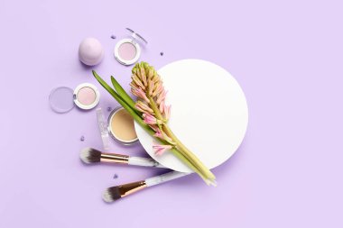 Composition with blank card, hyacinth flower and cosmetics on lilac background