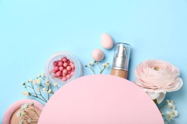 Composition with blank card, decorative cosmetics and flowers on color background