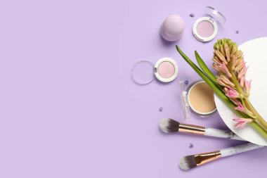 Composition with hyacinth flower and cosmetics on lilac background
