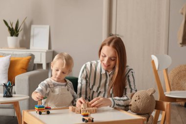 Mother and her little son playing with toys at home