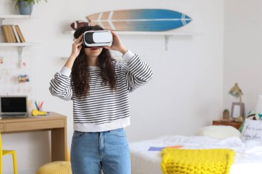 Teenage girl in VR glasses at home