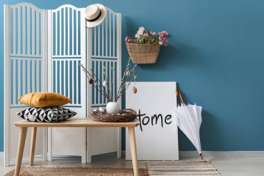 Stylish interior of modern living room with Easter decor and umbrella