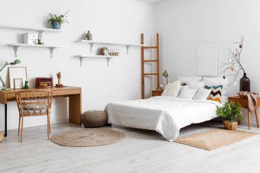 Stylish interior of light bedroom with Easter decor and comfortable bed