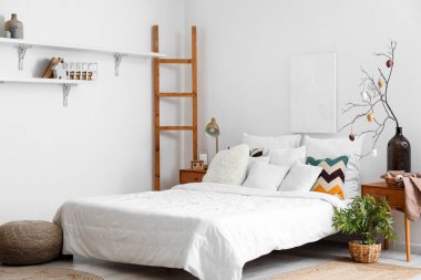 Stylish interior of light bedroom with Easter decor and comfortable bed