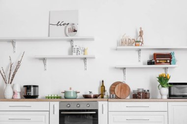 Interior of kitchen with Easter decor, white counters and shelves
