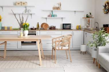 Interior of kitchen with Easter decor, white counters and dining table