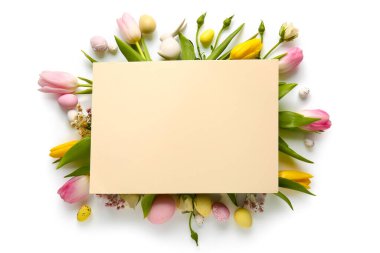 Composition with blank card, beautiful flowers and Easter eggs on white background
