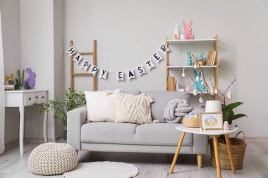 Interior of living room with Easter decor, tables and sofa