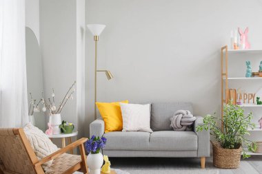 Interior of living room with Easter decor, sofa and lamp