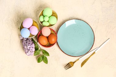 Table serving with Easter eggs, hyacinth flowers and green plant branch on beige background