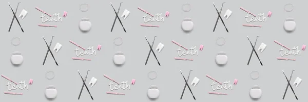 Many models of tooth with dentist\'s tools, paste and toothbrushes and dental floss on grey background. Pattern for design