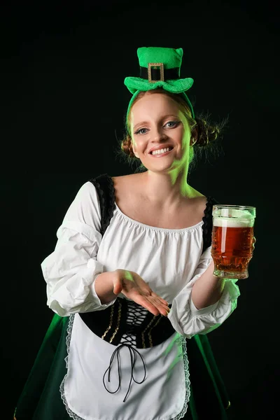Irish waitress with glass of beer on dark background. St. Patrick\'s Day celebration
