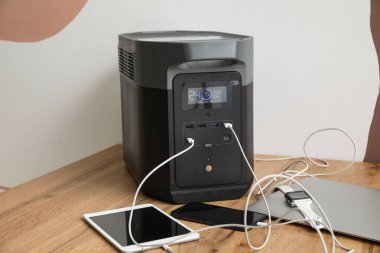 Portable power station charging gadgets near wall