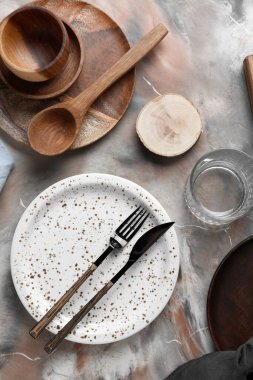 Beautiful table setting with wooden plates on grunge background