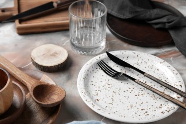 Beautiful table setting with wooden plates on grunge background, closeup
