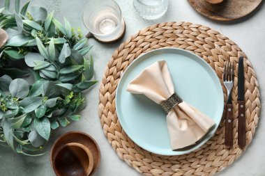 Beautiful table setting with mistletoe wreath on grunge background