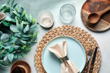 Beautiful table setting with mistletoe wreath on grunge background