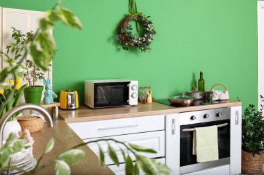 Interior of stylish kitchen with Easter wreath and white counters