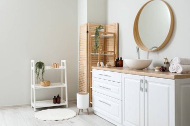 Interior of light bathroom with counters, sink and mirror