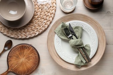 Stylish table setting with cutlery and plates on white wooden background