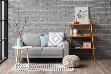 Interior of modern living room with willow branches in vase and sofa