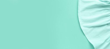 Soft fabric on mint background with space for text