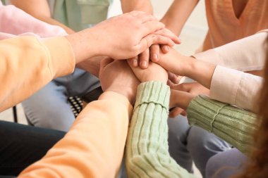 Group of people praying with Holy Bible in room, closeup