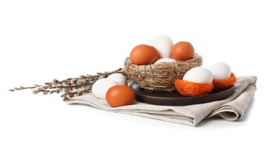 Nests with Easter eggs and willow branches on white background
