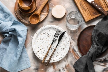 Beautiful table setting with wooden plates on grunge background
