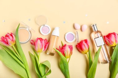 Composition with beautiful tulip flowers, cosmetics and makeup sponges on color background