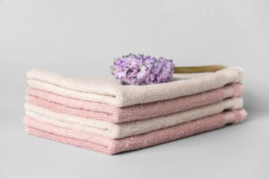 Stack of soft towels and hyacinth flower on white background