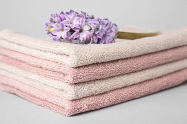 Stack of soft towels and hyacinth flower on white background, closeup