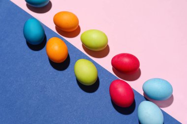 Composition with painted eggs for Easter celebration on color background