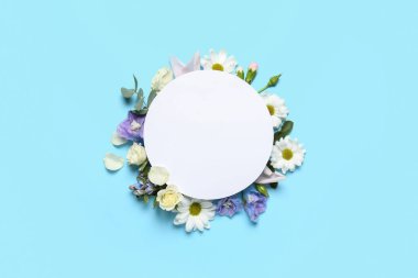 Beautiful spring composition with blank card and flowers on color background