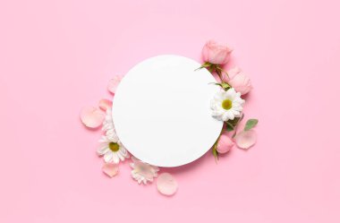 Composition with blank card and spring flowers on pink background