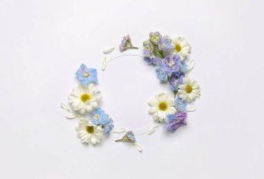 Blank round frame with beautiful chrysanthemum and delphinium flowers isolated on white background