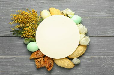 Blank card with flowers, eggs and treats on dark wooden background. Novruz Bayram celebration