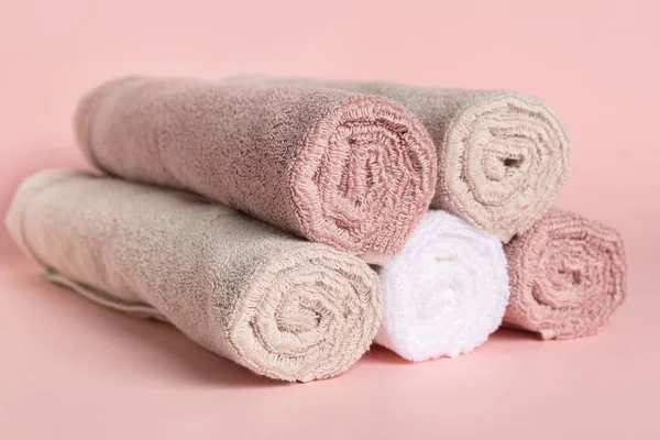 Rolled clean towels on pink background